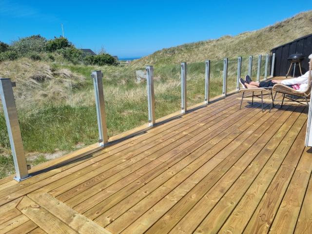 Træterrasse med klart glashegn på stålstolper
